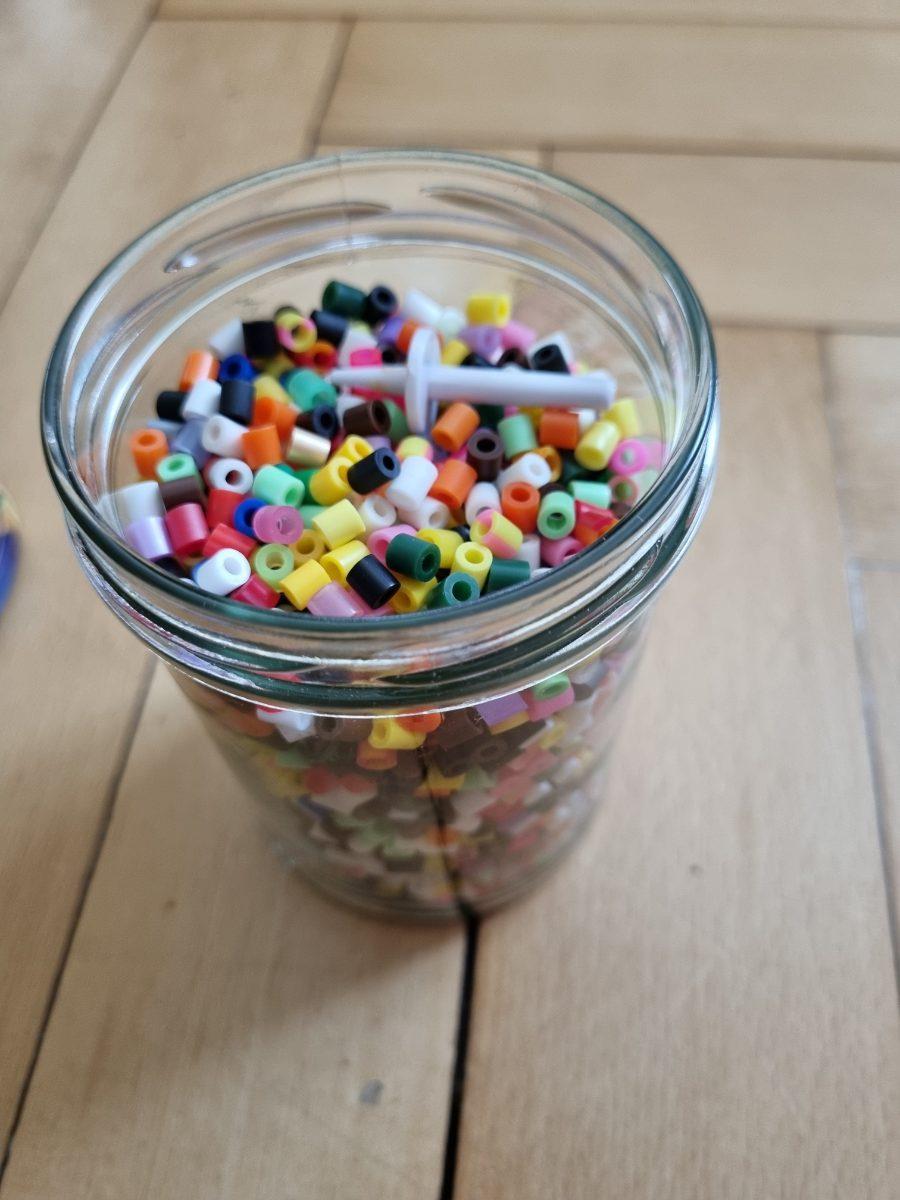 Glas mit Perlen und Zubehör